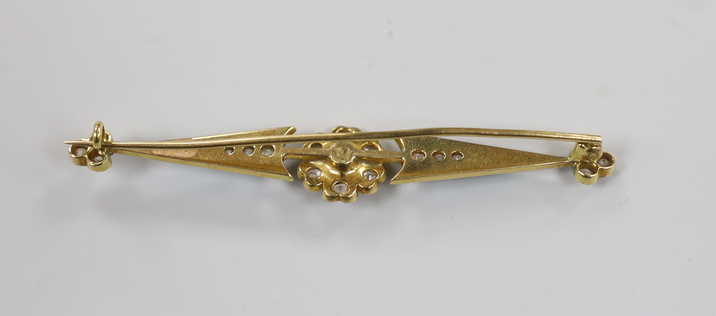 A yellow metal, emerald and diamond cluster set enamelled bar brooch, 74mm, gross weight 8.9 grams.